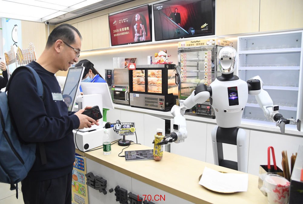 4月22日，在北京市海淀区中关村大街一座大厦内的便利店，机器人将抓取好的饮料交给顾客。新华社记者 任超 摄